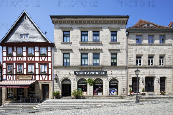 Beautiful row of houses, from left, residential building, half-timbered building, commercial building, three-storey corner building with gabled roof, two half-timbered upper storeys, 1746, gable slated, town pharmacy 1846, three-storey sandstone ashlar building with hipped roof, classicism, three-storey sandstone ashlar building with hipped roof, mid-19th century, Birthplace of Bishop Josef Stangl, AmtsgerichtsstraÃŸe, cobbled, Upper Town, Old Town, Kronach, Upper Franconia, Franconia, Bavaria, Germany