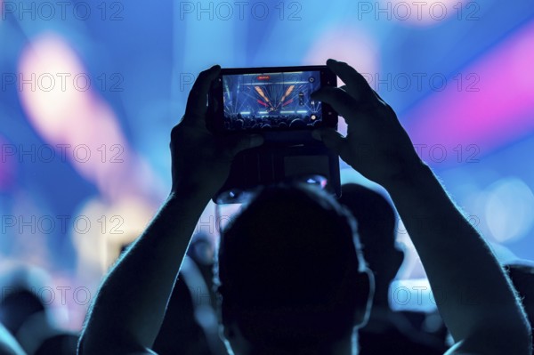 A concertgoer films Lionel Richie with his smartphone on the Say Hello To The Hits 2025 Tour at the Uber Arena in Berlin on 3 July 2025