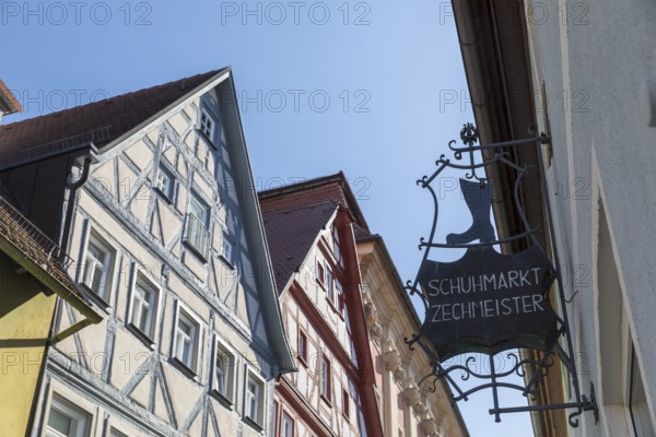 Advertising sign of the Zechmeister shoe market, behind it the half-timbered gables of the old town, Bad Windsheim, Bavaria, Germany