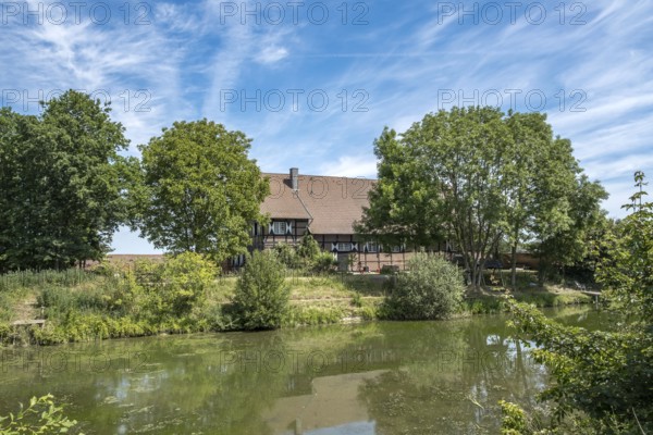 A house on the banks of the river Stever, surrounded by trees under a blue sky, MÃ¼nsterland, North Rhine-Westphalia, Germany