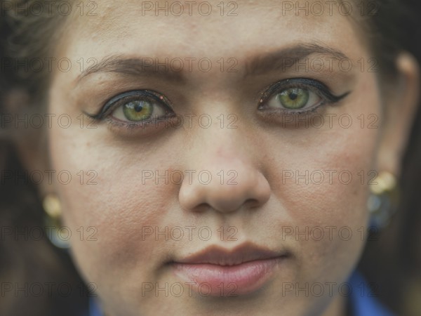 Close up of Latin American girl face looking and smiling at the camera. Portrait of attractive latin girl smiling outdoors