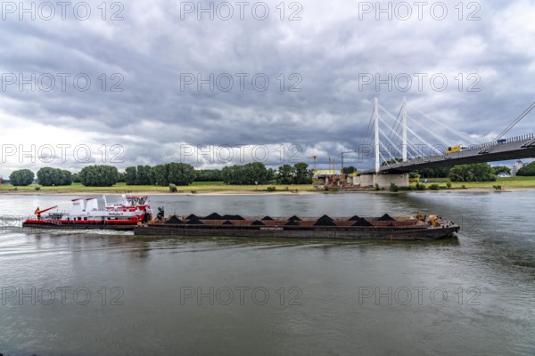 Rhine bridge Duisburg-Neuenkamp, the A40 motorway, start of construction of the second bridge, bridge piers and the first bridge segment are erected on the Neuenkamp side of the Rhine, cargo ship on the Rhine, push boat Herkules II, push convoy, with coal for the HKM coking plant in Duisburg, North Rhine-Westphalia, Germany