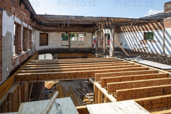 Detroit, Michigan - Workers rehab a long-vacant and crumbling commercial building in the Morningside neighborhood. The project, called Ultreia, will contain first floor commercial space and apartments above