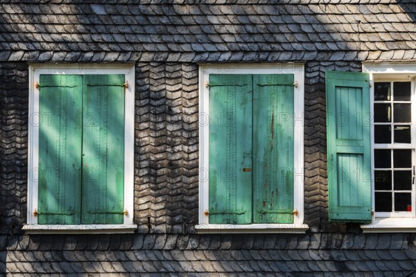 Weathered green shutters on a slate-clad house in Wuppertal, Germany