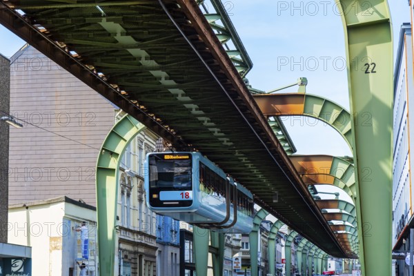 The Wuppertal suspension railway runs through Vohwinkel in front of buildings from the Wilhelminian era near the Bruch stop in Wuppertal, Germany