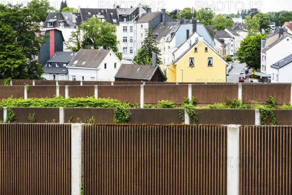 A row of noise barriers in front of a residential area at the Sonnborn junction in Wuppertal, Germany