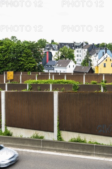 A row of noise barriers in front of a residential area at the Sonnborn junction in Wuppertal, Germany