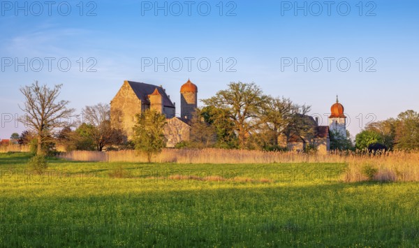 View over wildflower meadow at Sommersdorf Castle near Burgoberbach in the AltmÃ¼hl Valley in the evening light, Middle Franconia, Bavaria, Germany