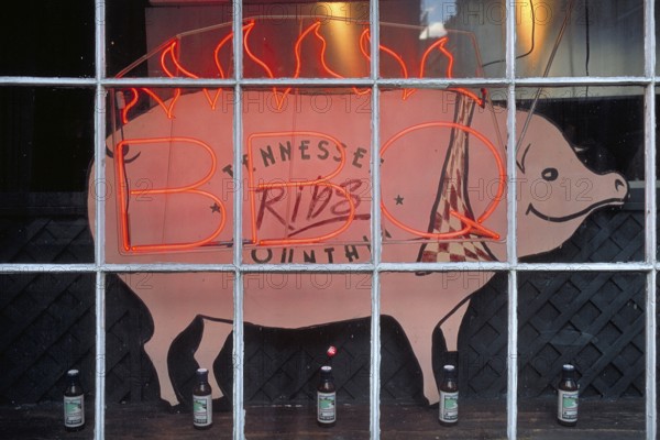Illuminated advertising for BBQ, barbecue, grill, with a pig figure in a shop window, Manhattan, New York City, USA