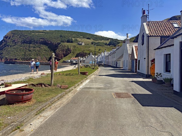 Picturesque coastal road along a small village with houses and a rocky coastline in serene weather, Local Hero, burt Lancaster, Pennan, film location, Aberdeenshire, Scotland, United Kingdom