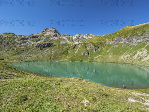 Hiker at lake Engeratsgundsee, mountain range between Oberstdorf and Bad Hindelang, Allgaeu, Bavaria, Germany