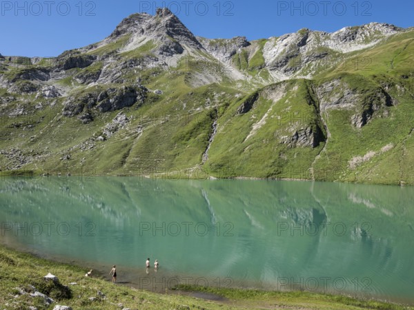 HIker at lake Engeratsgundsee, mountain range between Oberstdorf and Bad Hindelang, Allgaeu, Bavaria, Germany