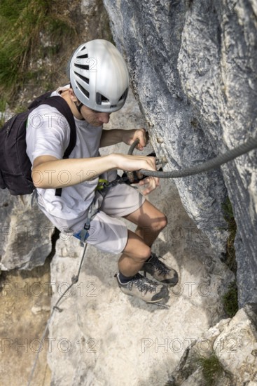 Mountaineer climbing over a steep wall in the Isidor via ferrata, GrÃ¼nstein, Schönau am Königssee, Berchtesgadener Land, Upper Bavaria, Bavaria, Germany