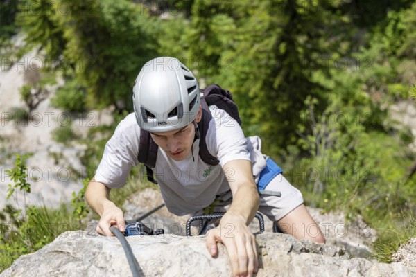 Mountaineer climbing over a steep ladder in the Isidor via ferrata, GrÃ¼nstein, Schönau am Königssee, Berchtesgadener Land, Upper Bavaria, Bavaria, Germany