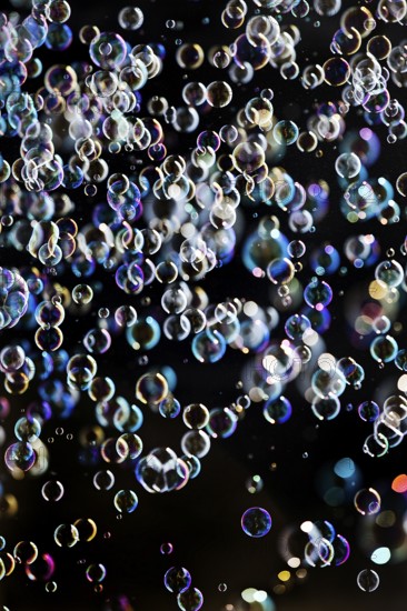 Many, small iridescent and floating soap bubbles against a black background, Recklinghausen, North Rhine-Westphalia, Germany