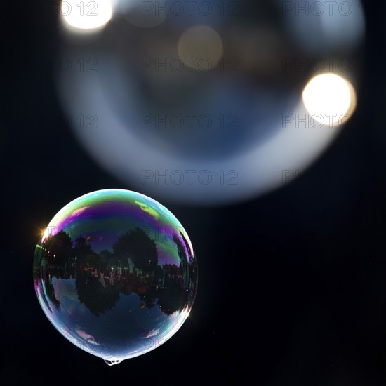 Two shimmering and floating soap bubbles against a black background, Recklinghausen, North Rhine-Westphalia, Germany