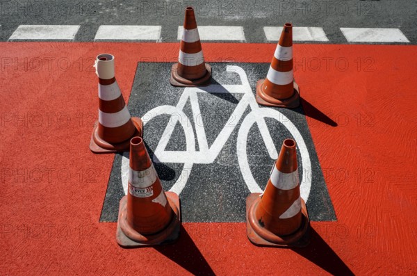 Warning cones standing on a cycle path sprayed with a stencil Symbol on a newly built cycle path, Berlin, 02.07.2025, Berlin, Berlin, Germany