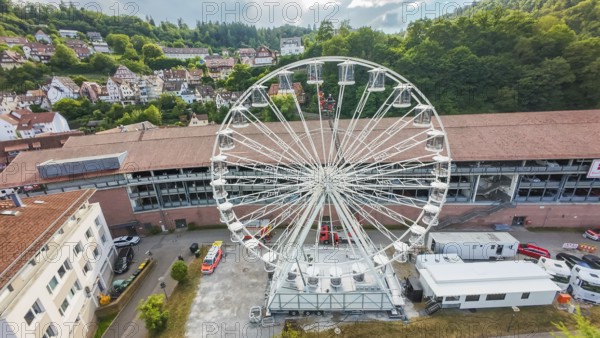 Urban landscape with a central Ferris wheel surrounded by trees, fire brigade exercise for gondola rescue, Germany