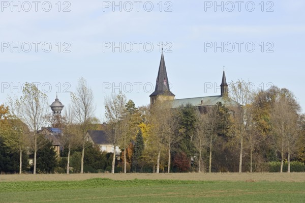 Landmarks... Lank-Latum, district of Meerbusch, Rhein-Kreis Neuss, North Rhine-Westphalia, View over the Pappelallee to St. Stephanus together with the distinctive water tower typical for the townscape, Lower Rhine, Germany, Western Europe