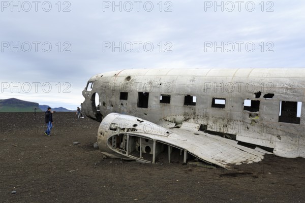Tourist photographing aircraft wreckage, US Navy Douglas DC-3 transport plane, Sander, volcanic landscape, SÃ³lheimasandur, Solheimasandur, near ring road, SuÃ°urland, Sudurland, South Iceland, Iceland