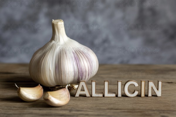 Garlic bulb on walnut table with cloves spelling Allicin. Rustic still life celebrating flavor and natural health. Generative ai, AI generated