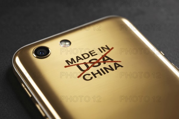 Close-up of Made in USA text crossed out and replaced with China on back of shiny golden smartphone. Concept of misleading labeling and global manufacturing. Generative ai, AI generated