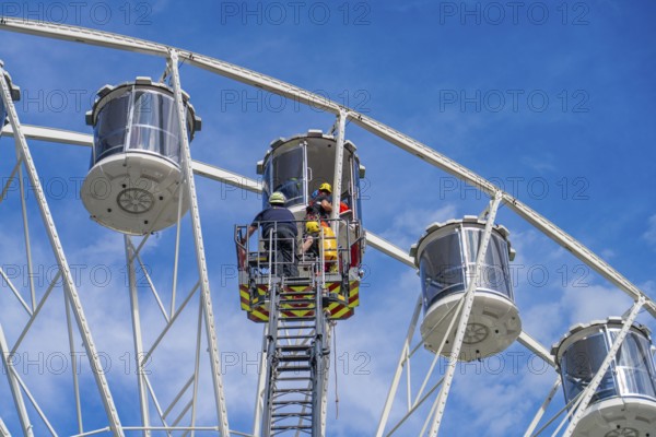Rescue workers assist in a rescue mission in a Ferris wheel cabin, fire brigade exercise for gondola rescue, Germany