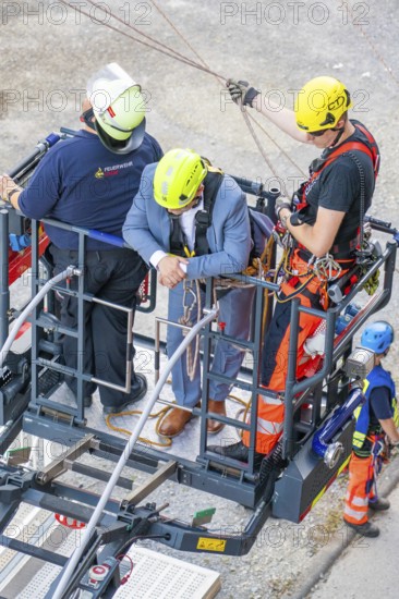 Firefighters secure person on lifting platform during rescue operation, Fire brigade exercise for gondola rescue, Germany