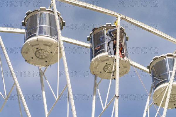 Detailed view of two giant wheel cabins in front of a clear blue sky, fire brigade exercise for gondola rescue, Germany
