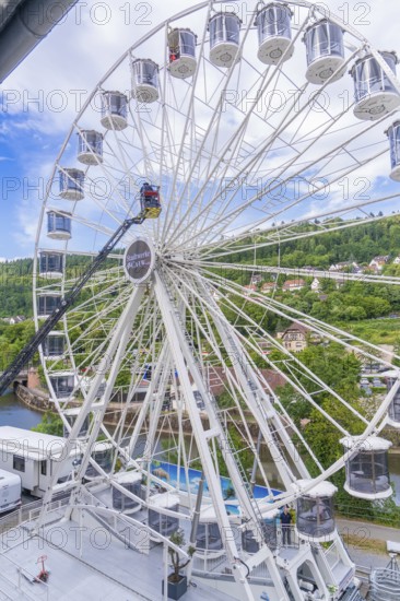 Large Ferris wheel with a view of a green landscape and houses in the background, fire brigade exercise for gondola rescue Ferris wheel, Calw, Germany