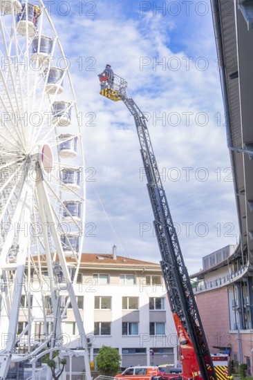Fire brigade ladder next to a building front with operating platform in use, fire brigade exercise for gondola rescue Ferris wheel, Calw, Germany