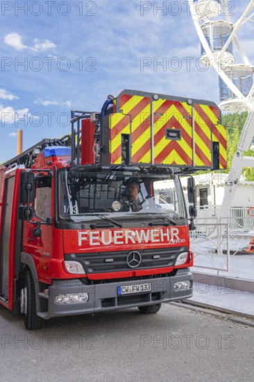 Fire engine with lifting mechanism parked in an urban environment, fire brigade exercise for gondola rescue Ferris wheel, Calw, Germany