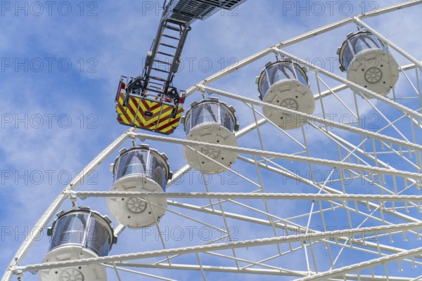 Fire brigade operation on a large Ferris wheel under a blue sky, fire brigade exercise for gondola rescue Ferris wheel, Calw, Germany