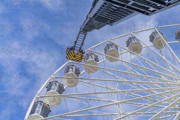 Fire brigade ladder extends to the cabins of the Ferris wheel, clear sky in the background, fire brigade exercise for gondola rescue Ferris wheel, Calw, Germany
