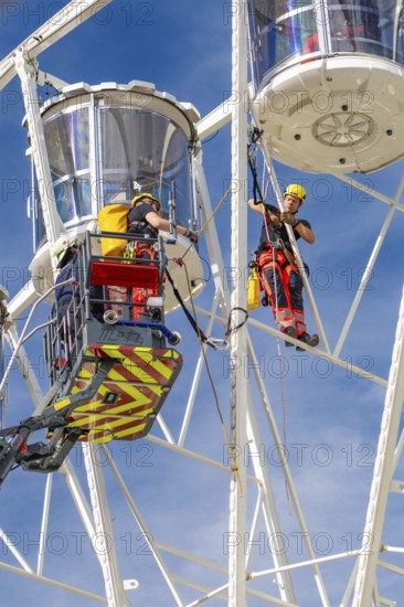 Worker with safety equipment during maintenance work on a Ferris wheel, fire brigade exercise for gondola rescue Ferris wheel, Calw, Germany