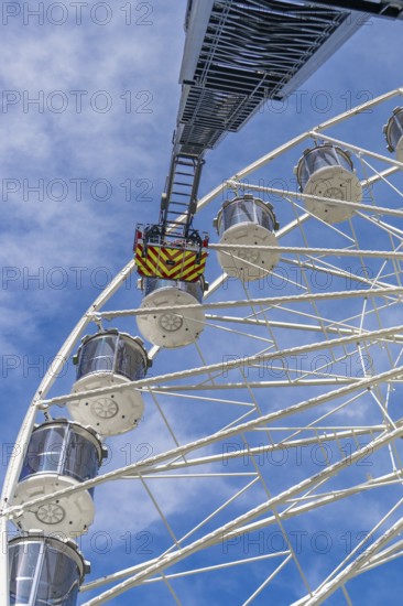 Fire brigade ladder extends against the sky to the cabins of the Ferris wheel, ready for a rescue, Fire brigade exercise for gondola rescue Ferris wheel, Calw, Germany