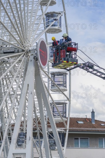 Firefighters in the rescue cage near the Ferris wheel, a building is visible in the background, fire brigade exercise for gondola rescue Ferris wheel, Calw, Germany
