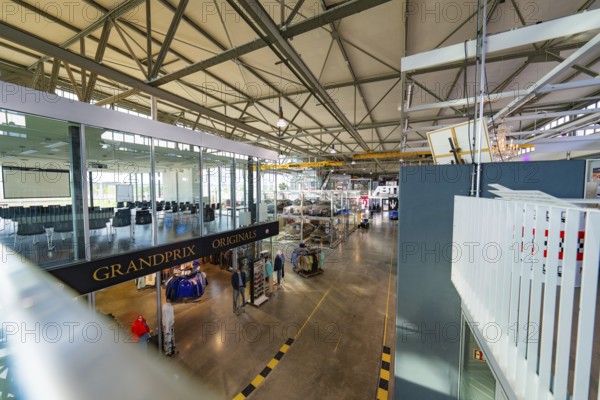 Large industrial hall with exhibited vehicles, modern architecture and bright lighting, Motorworld, Böblingen, Germany