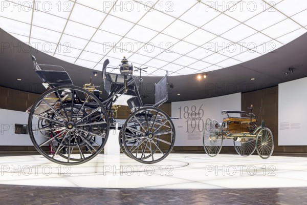 Motorised carriage by Gottlieb Daimler from 1886 (left) . The world's first four-wheeled automobile. The Mercedes-Benz Museum in Stuttgart presents a journey through the automotive history of the global corporation. The history of the Mercedes star begins with the first automobile in 1886. 160 vehicles are on display. Stuttgart, Baden-WÃ¼rttemberg, Germany