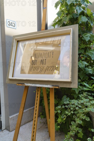 Artwork on easel next to a plant in front of a grey wall, Merano, South Tyrol, Italy