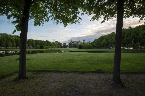 Schwerin Castle in the distance, framed by the symmetrical rows of trees in the castle garden, Schwerin, Mecklenburg-Vorpommern, Germany