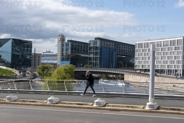 Modern city view with glass buildings, bridge and river under a cloudy sky, Berlin Central Station, Berlin, Germany