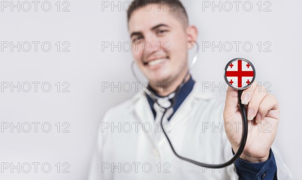 Doctor showing stethoscope with Georgia flag. Georgia national healthcare concept