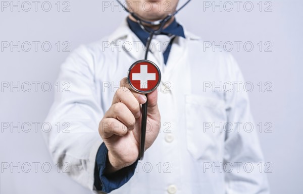 Doctor hands holding stethoscope with Switzerland flag. Switzerland health and care concept