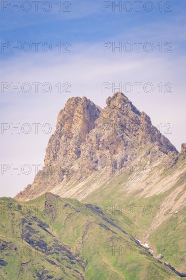 Barren rock towers into the clear blue sky, surrounded by gentle green slopes, hike to the Schlehrn, Alpe di Siusi, Dolomites, South Tyrol, Italy