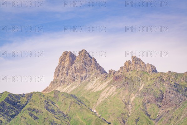 Mountain peaks rise into the sky, surrounded by green slopes and blue sky, hike to the Schlehrn, Alpe di Siusi, Dolomites, South Tyrol, Italy