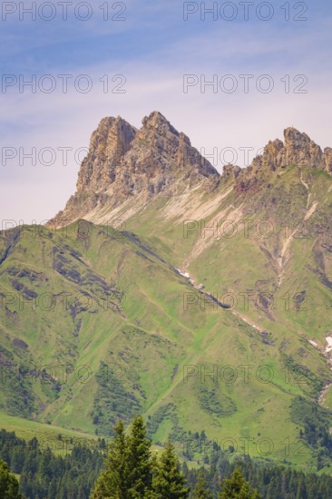 Massive mountain peaks with green slopes and minute skies over the landscape, hike to the Schlehrn, Alpe di Siusi, Dolomites, South Tyrol, Italy