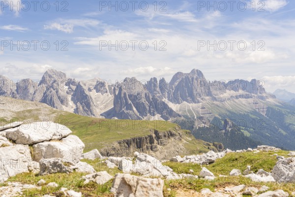 Majestic mountains under a blue sky with white clouds and green vegetation in the foreground, hike to the Schlehrn, Alpe di Siusi, Dolomites, South Tyrol, Italy