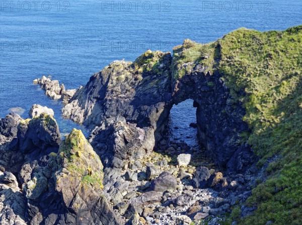 Rocky coast and rock gate on the south-east coast near the southern tip of Cornwall on the English Channel. Cadgwith, Cornwall, South West England, Great Britain