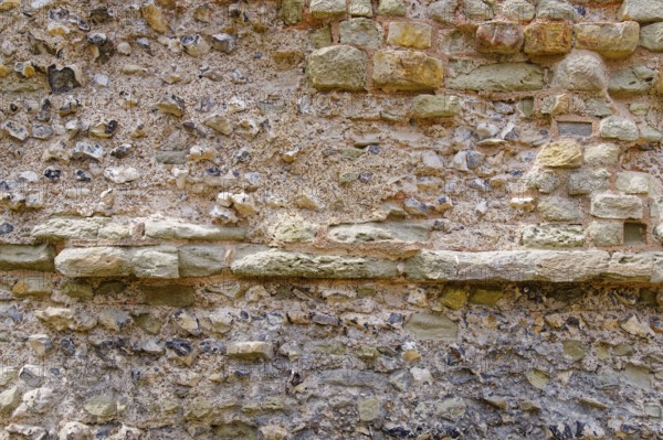 Masonry of the historic castle wall of Pevensey Castle, a Norman castle, in the village of Pevensey, Sussex, England, Great Britain